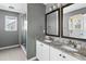 Bathroom features granite countertops, white cabinets, dual sinks, decorative mirrors, and glass shower with tiled wall at 129 E Hartwick Ln, Goose Creek, SC 29445