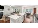 Open kitchen with a white island, stainless steel appliances, hardwood floors, and a view into the living room at 1601 Thin Pine Dr, Johns Island, SC 29455