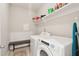 Bright laundry room features modern appliances, overhead shelving, and neutral tones at 1601 Thin Pine Dr, Johns Island, SC 29455