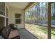 Covered porch includes wicker seating with view of fenced backyard with mature trees at 1601 Thin Pine Dr, Johns Island, SC 29455