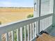 Balcony with distant view of golden grassy landscape, featuring white railings and wicker furniture at 166 W Mariners Cay Dr, Folly Beach, SC 29439
