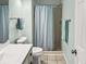 Clean and minimalist bathroom with a shower, toilet, vanity and soothing blue accents at 166 W Mariners Cay Dr, Folly Beach, SC 29439