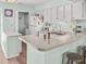 Bright kitchen featuring white cabinets, a breakfast bar, modern appliances and a laundry closet at 166 W Mariners Cay Dr, Folly Beach, SC 29439