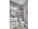 A serene powder room with a stylish vanity, round mirror, floating shelves, and modern fixtures at 1847 Grovehurst Drive, Charleston, SC 29414