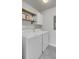 Well-lit laundry area featuring a washer, dryer, and open shelving for storage solutions at 1847 Grovehurst Drive, Charleston, SC 29414
