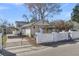 Exterior shot showcasing the home's facade, gated yard, and a carport on the side at 1987 Echo Ave, North Charleston, SC 29405