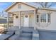 Close-up of a home's covered porch, featuring gray steps and stylish exterior lighting at 1987 Echo Ave, North Charleston, SC 29405