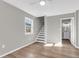 Bright living room with wood floors, ceiling fan, and access to the stairway and bathroom at 1987 Echo Ave, North Charleston, SC 29405