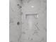 Close up of the updated shower with marble tile and a built-in soap dish at 1987 Echo Ave, North Charleston, SC 29405
