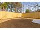 Spacious fenced backyard with a small concrete patio and natural surroundings at 2008 Emden St, North Charleston, SC 29406