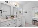 Bathroom with double vanity, modern mirrors, sconces, and white cabinets at 2008 Emden St, North Charleston, SC 29406