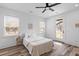 Bright bedroom with a ceiling fan, two windows, white bedding, and a glass door to the backyard at 2008 Emden St, North Charleston, SC 29406