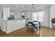 Bright dining area with a modern light fixture and a view of the kitchen featuring white cabinets and countertops at 218 Mayfield Dr, Goose Creek, SC 29445