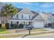 Charming two-story home with a manicured lawn, a palm tree and an attached two car garage at 218 Mayfield Dr, Goose Creek, SC 29445