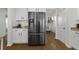 Modern kitchen with stainless steel refrigerator and sleek white cabinets, with dining room visible in the background at 218 Mayfield Dr, Goose Creek, SC 29445
