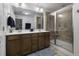 Well-lit main bathroom with dual sinks, wood cabinets, and a glass-enclosed shower at 218 Mayfield Dr, Goose Creek, SC 29445