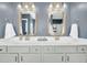 Bathroom featuring a double sink vanity, framed mirrors, modern lighting, and granite countertop at 231 Laurel Crest Way, Summerville, SC 29486