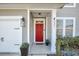 Close-up of a red front door with sidelights, a storm door, and decorative plants at 231 Laurel Crest Way, Summerville, SC 29486