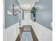 Well-lit hallway with hardwood floors, blue walls, and white trim, leading to the front door at 231 Laurel Crest Way, Summerville, SC 29486