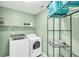 Functional laundry room with modern washer and dryer, metal shelving, and neutral paint for a practical space at 231 Laurel Crest Way, Summerville, SC 29486