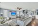 Bright living room with light blue walls, hardwood floors, a ceiling fan, and a staircase with dark railings at 231 Laurel Crest Way, Summerville, SC 29486