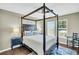 Bright main bedroom boasts a four poster bed, ceiling fan, blue accent rug, and a view from the window at 231 Laurel Crest Way, Summerville, SC 29486