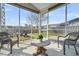 Relaxing screened porch with cozy seating, a small table, and views of the landscaped backyard at 231 Laurel Crest Way, Summerville, SC 29486