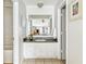 Bright bathroom vanity with granite countertops, cabinet storage, and a decorative mirror reflecting the living space at 2494 Etiwan Ave # 12J, Charleston, SC 29414