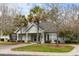 Attractive community building with a gray facade, white columns, and a well-maintained lawn with palm trees at 2494 Etiwan Ave # 12J, Charleston, SC 29414
