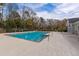 Inviting community pool surrounded by a spacious concrete deck, mature trees, and a black metal fence at 2494 Etiwan Ave # 12J, Charleston, SC 29414
