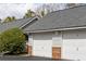 Detached garages featuring white doors with brick accents and gray siding, nestled among lush greenery at 2494 Etiwan Ave # 12J, Charleston, SC 29414