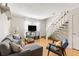 Inviting living room with hardwood floors, a comfortable sofa, staircase, and a mounted television at 2494 Etiwan Ave # 12J, Charleston, SC 29414