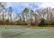 Full community tennis court enclosed by a fence and surrounded by lush trees and natural landscaping at 2494 Etiwan Ave # 12J, Charleston, SC 29414