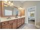 Bright bathroom with a double vanity, a large mirror, and an entrance to the primary bedroom at 2972 Riverwood Dr, Mount Pleasant, SC 29466