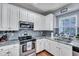 Well-lit kitchen with granite countertops, stainless steel appliances, and white cabinets at 3009 Macbeth Creek Dr, Charleston, SC 29414