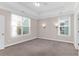 Spacious bedroom featuring tray ceilings, neutral walls, carpet flooring, and natural light from dual windows at 3042 Moonlight Dr, Charleston, SC 29414