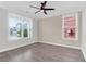 Bedroom with wood-look floors, two windows letting in natural light, ceiling fan and neutral paint at 3042 Moonlight Dr, Charleston, SC 29414
