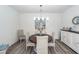 Bright dining area with modern light fixture, wood table, wicker chairs and coastal artwork at 305 Flowering Peach Ct # 202, Charleston, SC 29414