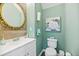 Stylish half bathroom with decorative mirror, wood accent wall, and modern fixtures at 315 Sabal Palmetto Ct, Moncks Corner, SC 29461