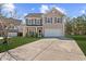 Charming two-story home with a well-manicured lawn and a large driveway on a sunny day at 315 Sabal Palmetto Ct, Moncks Corner, SC 29461