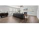 Cozy living room with fireplace, ceiling fan, hardwood floors and a large sectional sofa at 315 Sabal Palmetto Ct, Moncks Corner, SC 29461