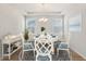 Elegant dining room with a round table, white chairs, a modern chandelier, and large windows, creating an inviting ambiance at 330 Pine Crest View Dr, Summerville, SC 29486