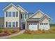 Inviting two-story home showcasing a brick-accented garage, complemented by vibrant landscaping and a paved walkway at 330 Pine Crest View Dr, Summerville, SC 29486