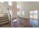 Open-concept living room boasts soaring ceilings, large windows, hardwood floors, and staircase to the upper level at 330 Pine Crest View Dr, Summerville, SC 29486