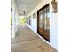 Charming porch featuring white columns, ceiling fan, copper lanterns, and elegant wood double doors at 3897 Summerton St, Mount Pleasant, SC 29466