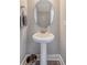 Pedestal sink in a half bathroom with a round mirror and decorative trim at 3941 Four Poles Park Dr, North Charleston, SC 29405