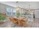 Dining area with a large wooden table, modern chandelier, and a view into the kitchen at 3941 Four Poles Park Dr, North Charleston, SC 29405