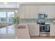 Well-lit kitchen with stainless steel appliances, quartz countertop island, and stylish tiled backsplash at 3941 Four Poles Park Dr, North Charleston, SC 29405