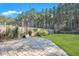 Serene backyard featuring a paver patio, green lawn, and wooded backdrop at 429 Cherrybark Oak St, Summerville, SC 29486