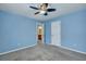 Blue bedroom features ceiling fan, neutral carpet, and view into the bathroom at 429 Cherrybark Oak St, Summerville, SC 29486
